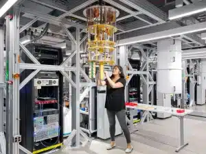 this photo shows a woman working on a piece of apparatus that is suspended from the ceiling of the laboratory